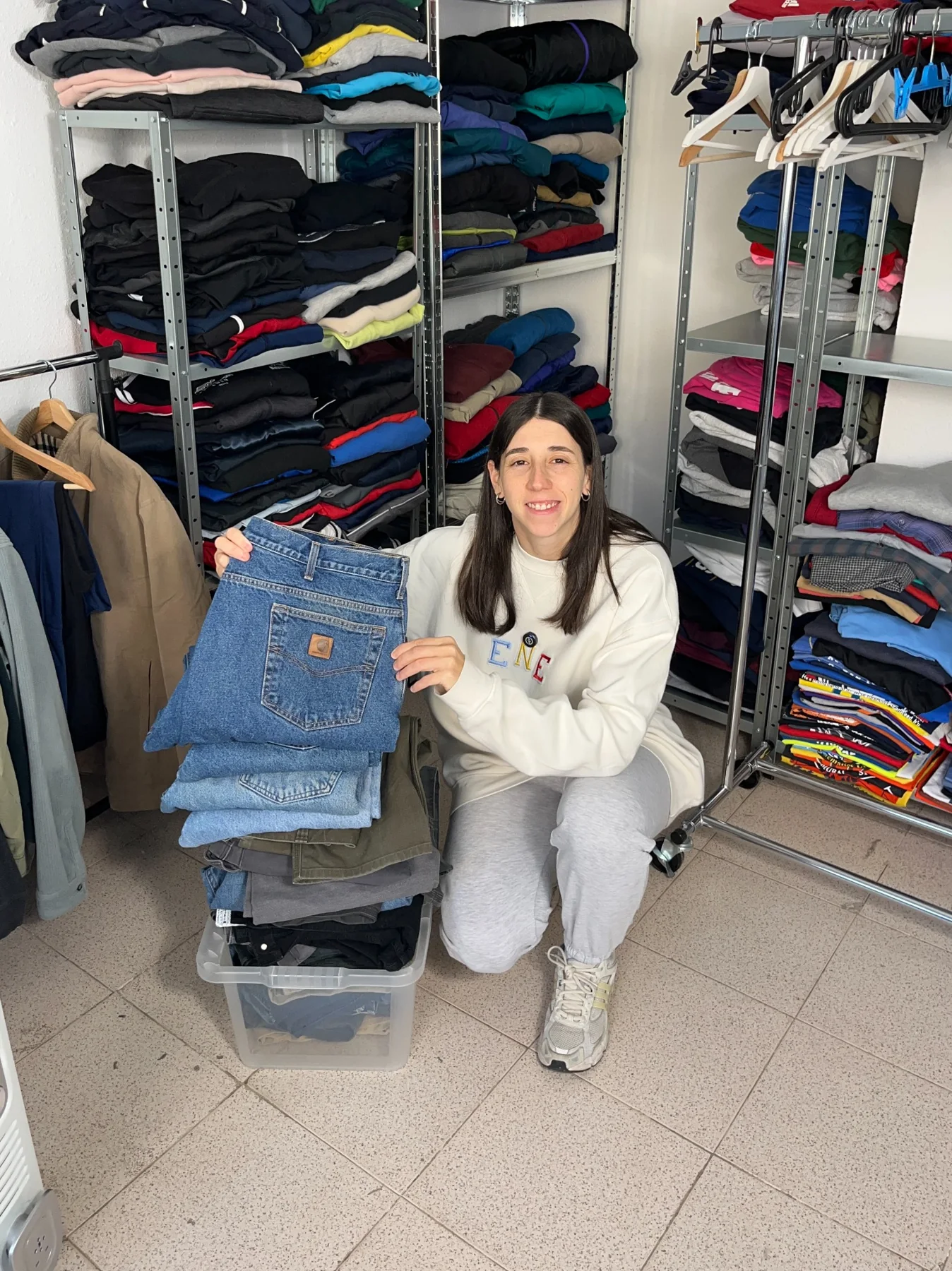 Natalia en su espacio de trabajo con un lote de ropa